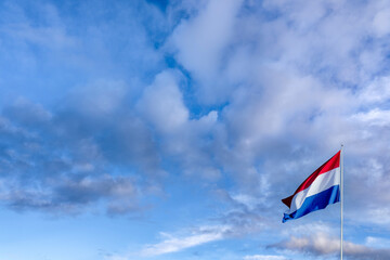 Waving Dutch flag against a cloudy sky