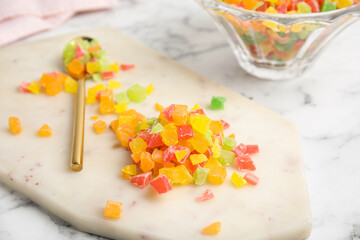 Mix of delicious candied fruits on white board, closeup