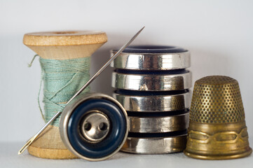 Thimble, buttons, and a spool of thread with a needle