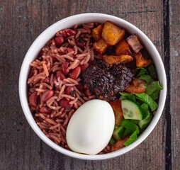 Waakye. Ghanaian rice and beans with an egg, kelewele, salad and shito