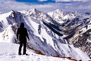Silhouette Standing On Top Of Epic Extreme Snow Covered Mountains - obrazy, fototapety, plakaty
