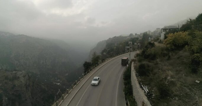 Drone aerial view, following a truck passing by and revealing the Guadisha valley. Daylight in cloudy sky. Real time.
