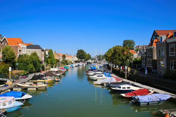 Fototapeta premium Dordrecht, Netherlands - July 9. 2021: View on water canal with inland yacht city harbor against blue summer sky