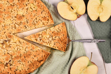 Slice of traditional European apple pie with topping crumbles called 'Streusel' on cake server