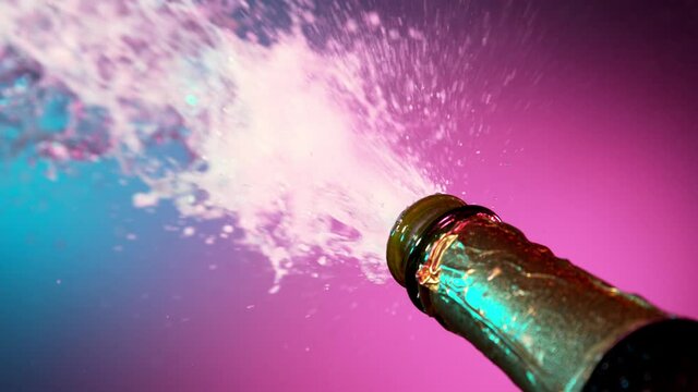 Super slow motion of Champagne explosion, opening champagne bottle closeup, illuminated with neon lights. Filmed on high speed cinema camera, 1000fps