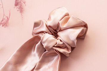Silk hair clip on pink background. Pink scrunchy. Elastic band for hair. Closeup