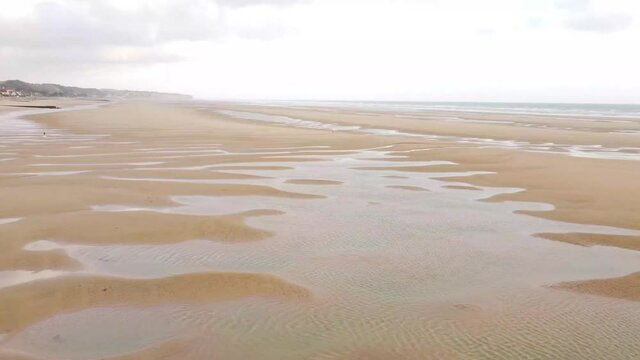 Young girl with a weimaraner dog playing on Omaha beach located in Normandy, France