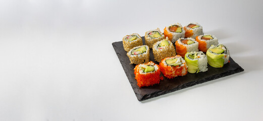 Sushi gourmet tray on slate surface on white background. Copy space. Selective focus.