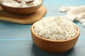 Delicious fresh cottage cheese on blue wooden table, closeup. Space for text