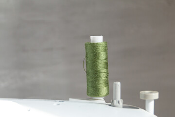 cotton Thread in green color against grey background, slow fashion and home sewing concept