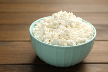 Delicious fresh cottage cheese on wooden table, closeup