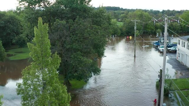 Street under flood rain water. Road covered with dirty water. Telephone poles and stop sign submerged after tropical storm hurricane damage in USA.