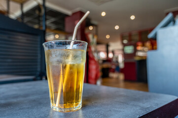 Glass of drink on table with paper straw.
