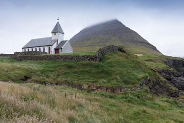 The top of the mountain of Faroe islands. A view of high peaks of mountains on a sunny day. Ocean view. 
Beautiful panoramic view. Northern Europe. Travel concept