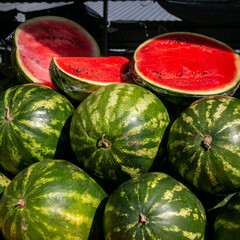 Lots of ripe watermelons. Selling watermelons at the grocery market. Vegetarian food.