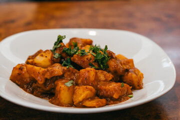 Plate of potatoes in sauce.