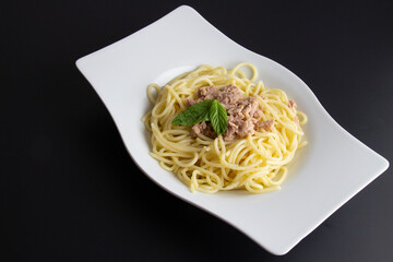 Spaghetti with tuna on a black background
