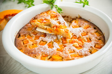 sweet pumpkin pie with pumpkin slices in a ceramic mold