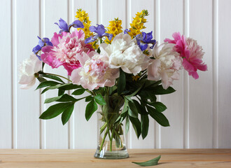  peonies and irises in a glass vase