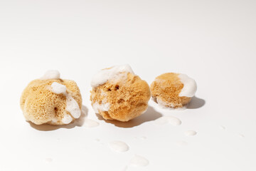 Yellow Natural bath or cleaning three sea sponges with foam on white background