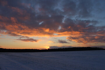 Winter landscape with a beautiful sunset over the field