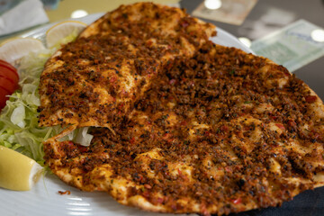 Lahmacun, known as Turkish pizza, on plate in Turkish restaurant, a photo of Turkish cuisine and baking 