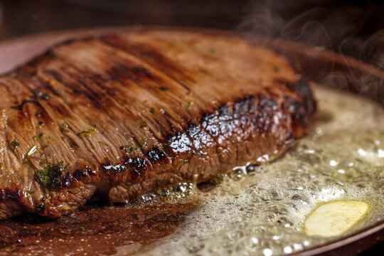 Frying flank steak with butter in a pan 