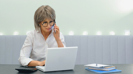 An elderly gray-haired angry businesswoman indignantly communicates with her subordinate employees...