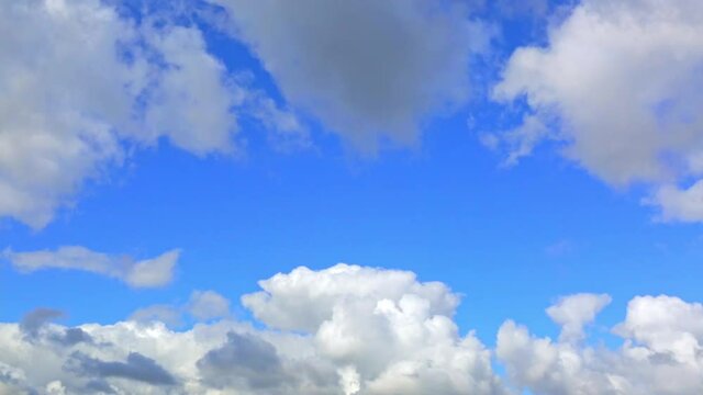 White clouds in the blue sky background. Sunny day. Partly cloudy. Weather forecast. Sunlight. Cloudscape. Wind move. Cyclone and anticyclone. HD video footage. Atmosphere pattern. Cumulus. Heavens.