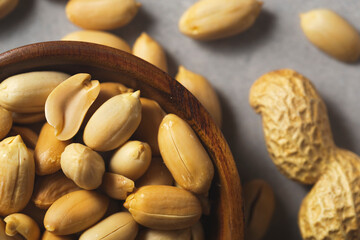 Peanuts in wooden bamboo bowl on concrete background. Nuts.