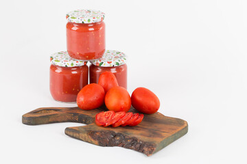 tomato sauces in handmade jar on wooden background and white background