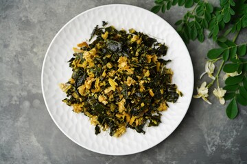 Moringa egg stir fry - healthy side dish with muringa leaves, selective focus