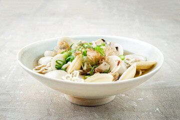 Traditional Japanese mussel ramen soup with noodles and bonito flakes served as close-up in a design bowl