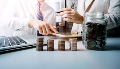 business people working at desk with piggy bank box.business finance saving and investment concept. hand put money coin into piggy bank for saving money wealth.