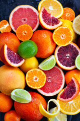 Close up of fresh juicy citrus fruits - oranges, mandarins, lemons and limes, top view