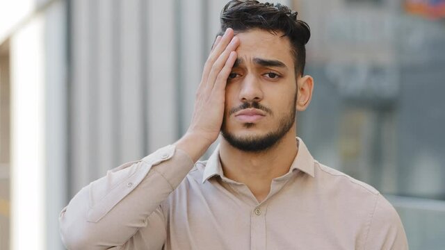 Arabian hispanic man bearded guy businessman have problem boss looser failure badly news feels frustrated cover face with palm looks very disappointed lost trouble unpleasant face outdoors in city