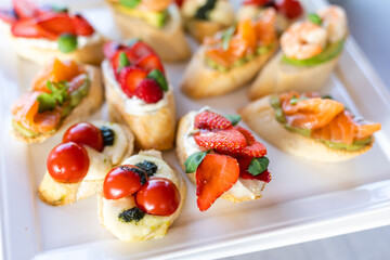 Bruschetta with tomatoes, mozzarella cheese and basil on a cutting board. Traditional italian appetizer or snack, antipasto. Caprese salad bruschetta. Top view with copy space.
