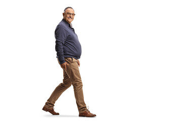 Fototapeta premium Full length profile shot of a mature smiling man walking