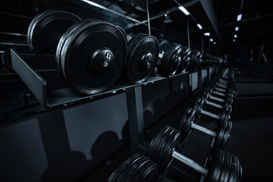 Rows of black dumbbells in the gym different weights