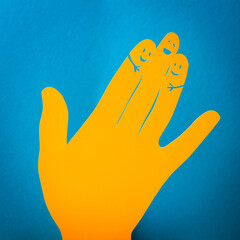 Papercut concept of three fingers hugging themselves. Happy orange paper hand on the blue background.