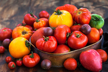 Fresh ripe red and yellow tomatoes on rustic background