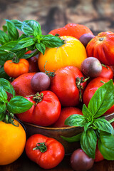 Fresh ripe red and yellow tomatoes on rustic background