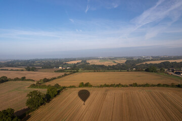 Obraz premium Aerial images of Wiltshire England taken from a hot air balloon. A cold and foggy morning flying over the recently harvested fields. 