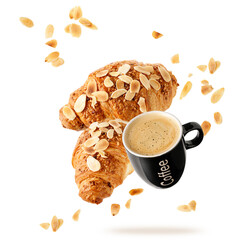 Fresh baked almond  breakfast croissants  with nuts crumbs and black cup hot espresso coffee flying isolated on white