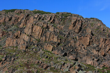 old crumbling rocky mountain on a blue sky background 