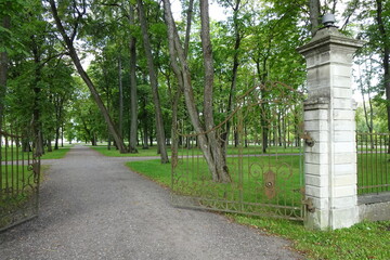 Open old wrought metal gates in Park Kadriorg on a summer. A lot of green grass and trees on the back. Tallinn, Estonia, Europe. August 2021