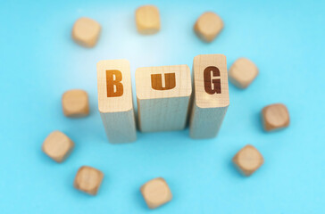 On a blue background, wooden cubes and Jenga with the inscription - BUG