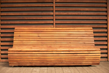 Wooden bench outside for seating. A resting place made of brown planks.