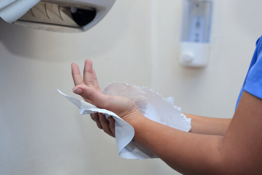 Woman drying her hands with paper towel