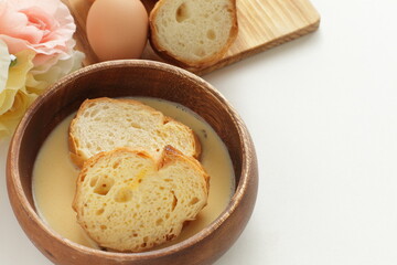 sliced French bread in egg wash for French toast cooking image